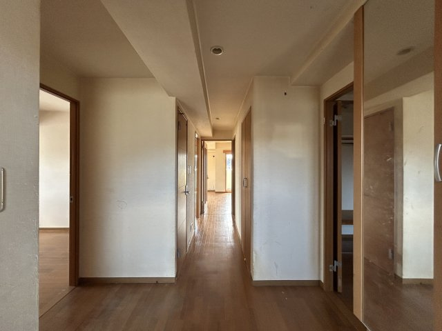 玄関から室内へ続く廊下は奥行きがあり、各居室へスムーズにアクセスできるゆとりある設計となっています。現在はリフォーム工事中ですが、内装が整うことでより明るく快適な住空間へと生まれ変わる予定です。
