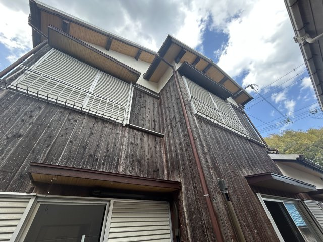 木の風合いを活かした外壁。全窓に雨戸が備わり防犯面も配慮。