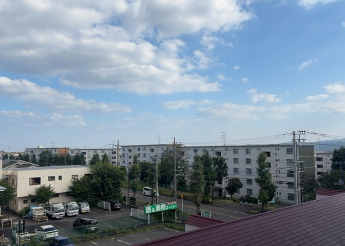 4階部分のバルコニーからの景色です。周囲に遮るものがなく、見晴らしの良い開放的な眺望が広がっています。気持ちの良い風を感じながら、四季折々の空の表情や街並みをゆったりと眺めることができます。