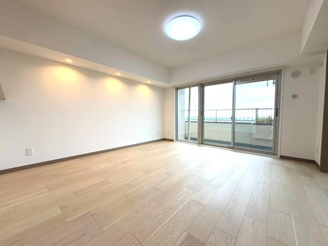 南向きバルコニーから陽光が降り注ぐ約13.5帖リビング。