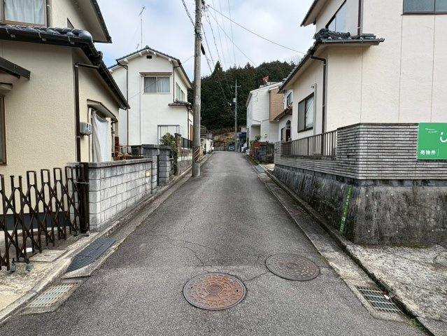 物件前面は住宅街の落ち着いた道路に面しており、周辺は戸建住宅が並ぶ静かな住環境です。交通量も比較的少なく車の出入りもしやすい立地。見通しの良い直線道路のため駐車時や車のすれ違いもしやすいのが特徴です。