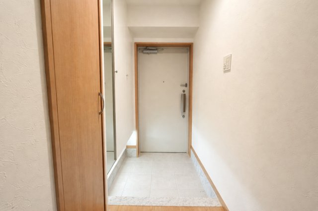 白を基調とした壁面と明るい建具が、清潔感のある第一印象を演出します。姿見付きの収納でお出かけ前の身だしなみチェックもスムーズ。廊下へと続く動線もゆとりがあり、来客時にも気持ちよく迎えられる空間です。