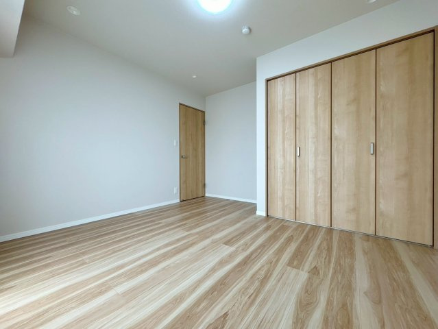 木目調のクローゼットを備えた洋室。シンプルな内装は家具が配置しやすく、子ども部屋や寝室に◎