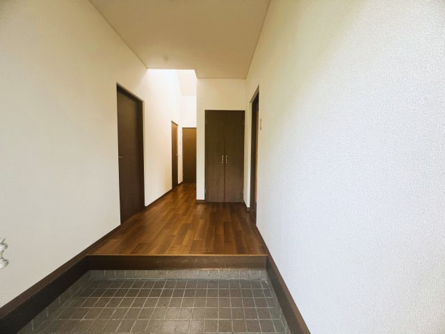 木目調の廊下と収納扉が落ち着いた温かみある空間