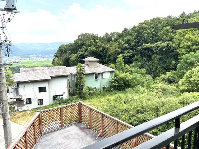 高台から緑豊かな山並みと田園風景を一望できる開放的な眺望