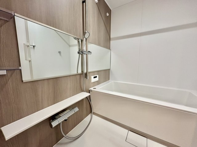 落ち着いた木目調のアクセントパネルを採用した浴室は、高級感のあるデザインで、一日の疲れをゆったりと癒せる空間となっています。　浴槽サイズは1418サイズとなっており足を伸ばしてごゆっくりお寛ぎできます