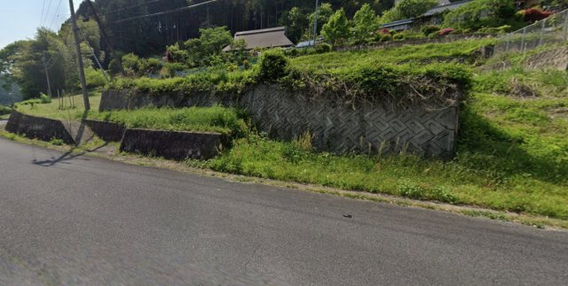 緑豊かな自然に包まれた、開放感あふれる売土地です。道路面より一段高くなっているため、プライバシーも確保しやすい立地です。周囲はのどかな住環境が広がり、四季の移ろいを身近に感じられるロケーションです。