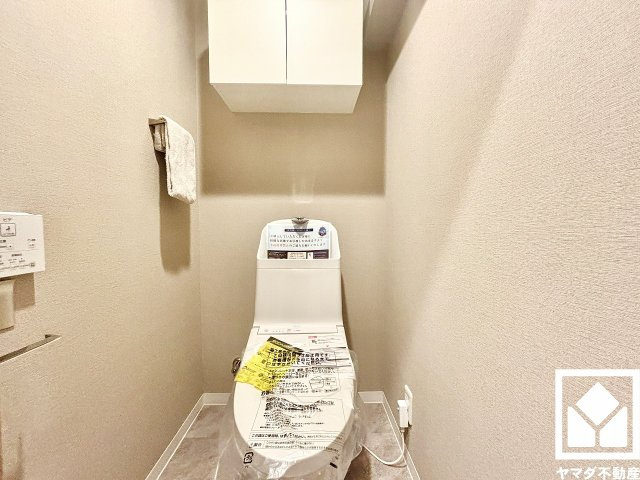 明るく清潔感溢れるトイレです。トイレットペーパーのストックや消耗品置き場などとしてお使いいただける吊戸棚がございます。