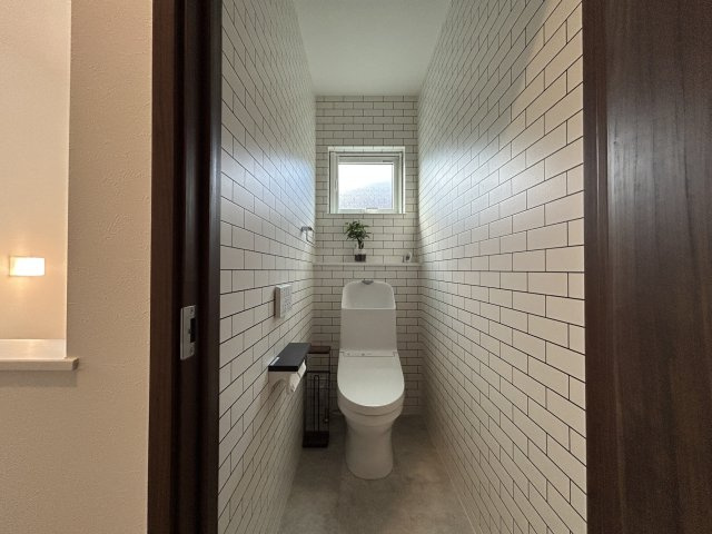 2階にもトイレを設置しているため、朝の忙しい時間帯や就寝時にも階段を使わず利用でき、ご家族が多いご家庭でも快適です。清潔感のあるタイル調クロスが印象的で、明るく爽やかな空間に仕上がっています。