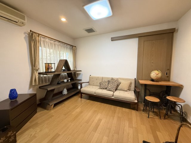 木目フロアが温かみを感じさせる洋室です。窓から自然光が差し込み、明るく居心地の良いお部屋です。収納スペースも備えており、寝室や子供部屋、書斎など用途に合わせて柔軟に利用できる空間となっています。
