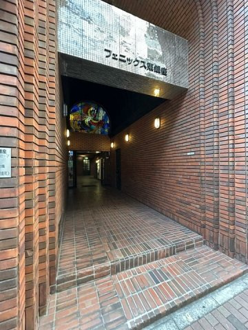 エントランスは、味わい深い赤レンガと独特な多角形の柱が織りなす、重厚で芸術的な空間です。暖かく照らされたトンネル状のアプローチを抜けると、奥には美しいステンドグラスが輝き隠れ家的な雰囲気が漂います。
