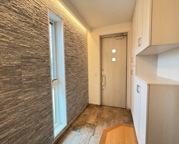 アクセントウォールが印象的な玄関は、上質で落ち着いた雰囲気を演出。収納も充実しており、靴や日用品をすっきり整理できます。窓から自然光が入り、明るく清潔感のある空間で来客を迎えられます。