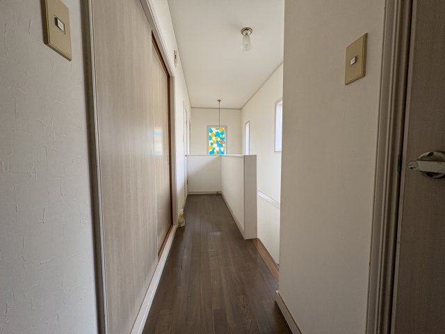 二階廊下は直線的で見通しが良く、各居室への移動がスムーズな設計。窓から自然光が入り、日中は明るく開放的な印象です。手すり付きで安心感があり、家族みんなが使いやすい動線が確保されています。