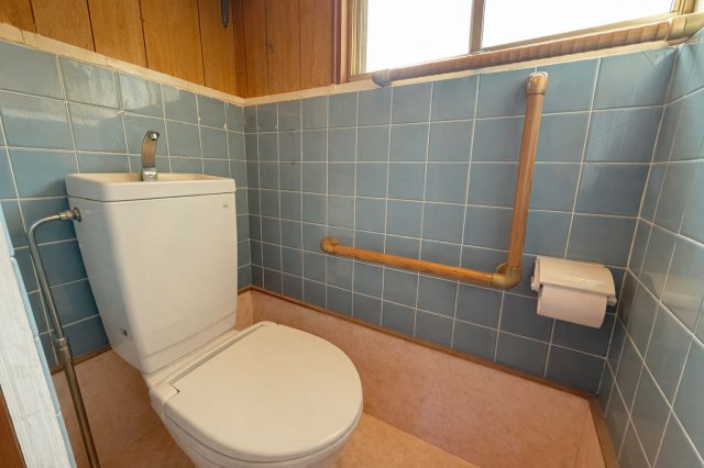 窓付きで明るく換気もしやすいトイレ空間です。手すりが設置されており、立ち座りのサポートにも配慮されています。シンプルな内装でお手入れもしやすい仕様です。独立空間として落ち着いて利用できる設計です。