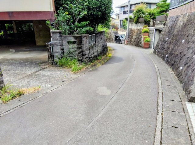 緑に囲まれた閑静な住宅街に位置する物件です。前面道路は落ち着いた雰囲気の坂道で、周辺からの視線が気になりにくく、プライバシ－を保ちやすい隠れ家的な立地が魅力です。