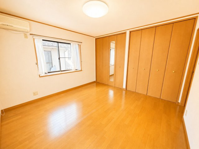 大型収納を備えた洋室です。壁一面に設けられた収納は、衣類やバッグ、季節用品などをまとめて収納できるため、お部屋をすっきり保てます。収納家具を置くスペースを抑えられるため、居室をより広く活用できます。