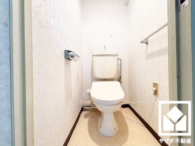 明るく清潔感溢れるトイレです。タオル掛けやペーパーホルダーが設置されています。