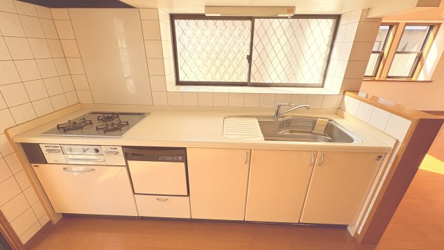 勝手口付きでゴミ出しや外への動線がスムーズな、使い勝手の良いキッチンです。食洗機を備えており、家事の負担を軽減できる点も魅力。広めのシンクと作業スペースでお料理もしやすく、収納も充実しています。