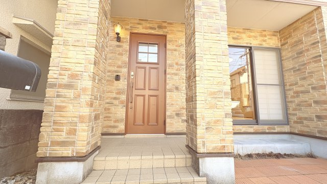 石目調の外壁と柱が印象的な玄関アプローチは、重厚感と高級感を感じさせるデザインです。屋根付きで雨の日でも濡れにくく、安心して出入りが可能。段差も緩やかで使いやすく、毎日の出入りを快適にサポートします。