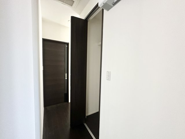 落ち着いた色合いの床と扉が印象的な廊下には、奥行きのある収納スペースを設けています。日用品や掃除道具の収納にも便利で、生活感を抑えた美しい空間づくりが可能。スライドドア仕様で使い勝手も良好です。