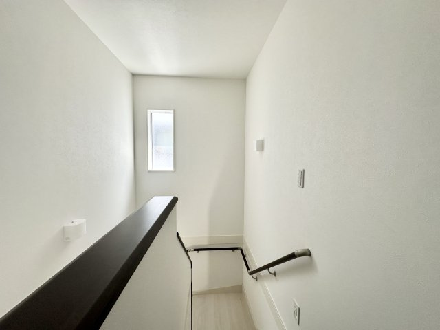 明るい自然光が差し込む階段スペースは、清潔感あふれるホワイト系で統一され、開放的な印象を与えてくれます。手すり付きで安全性にも配慮されており、小さなお子様やご年配の方にも安心、快適です。