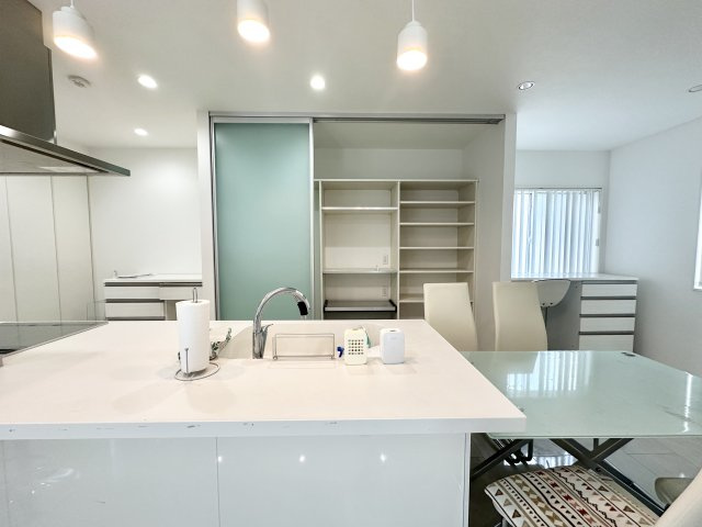 開放感あふれるキッチン空間は、ダイニングと一体となったスタイリッシュな設計。背面の可動棚は、パントリーや家電収納にも使える便利なスペースで、整理整頓もスムーズ。家族との会話も弾む心地よい場所です。