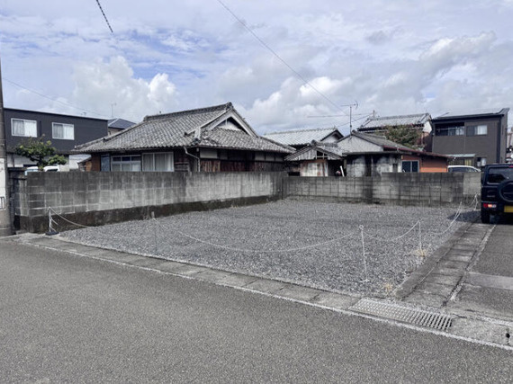 砂利敷きの現地。建物がないため、敷地全体の広さや形状を確認しやすくなっています。