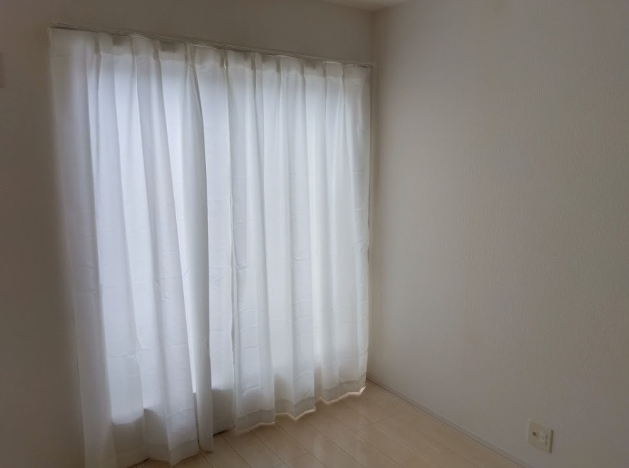 大きな窓から心地よい自然光が差し込む明るい洋室です。白を基調とした内装で、どんな家具も映える空間です。