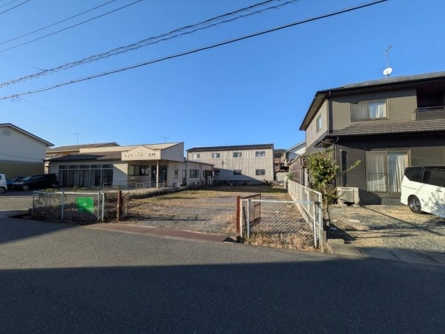 道路側から敷地全体を見渡せる現地写真です。住宅用地としてはもちろん、分譲用地など幅広い活用方法を検討できる土地です。周辺には戸建住宅も立ち並び、落ち着いた街並みが広がっています。