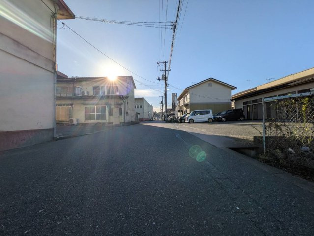 現地前面道路の様子です。周辺には住宅や事業所が立ち並び落ち着いた街並みが広がっています。通勤通学や日々のお出かけにも便利です。実際の道路幅員や車の通行状況、周辺環境などはぜひ現地にてお確かめください。
