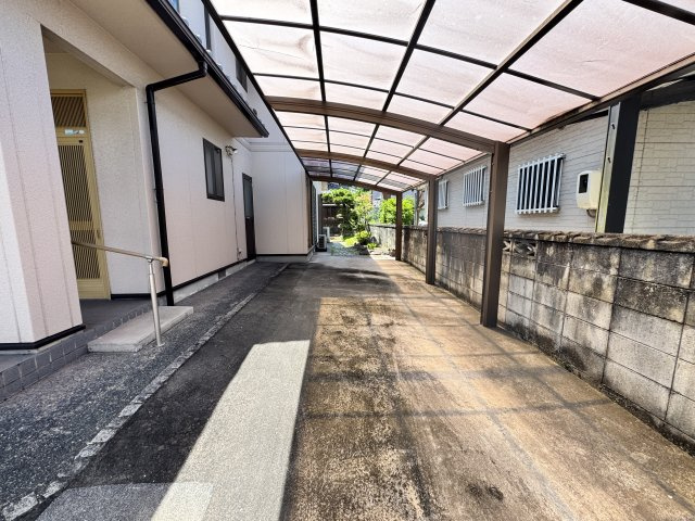 縦列2台分の駐車が可能な、ゆとりある広さを確保したカースペースです。大型のカーポートが設置されており、愛車を雨風や強い日差しからしっかりと守ります。コンクリート舗装で、雨の日でも足元が汚れず快適です。