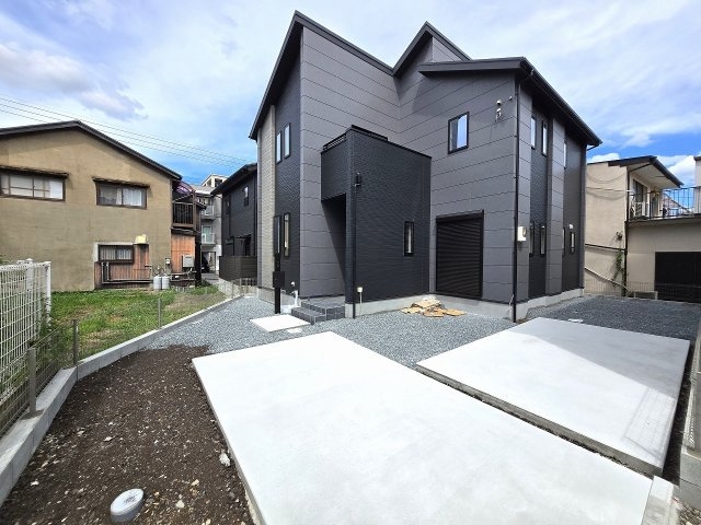 シャープな屋根形状と黒い外壁が映えるモダンな新築住宅