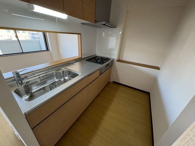 作業スペースにゆとりのあるシステムキッチンです。シンク・調理スペース・コンロがバランスよく配置され、効率的に調理が行えます。収納も上下に確保されており、調理器具や食器をすっきり整理可能です。