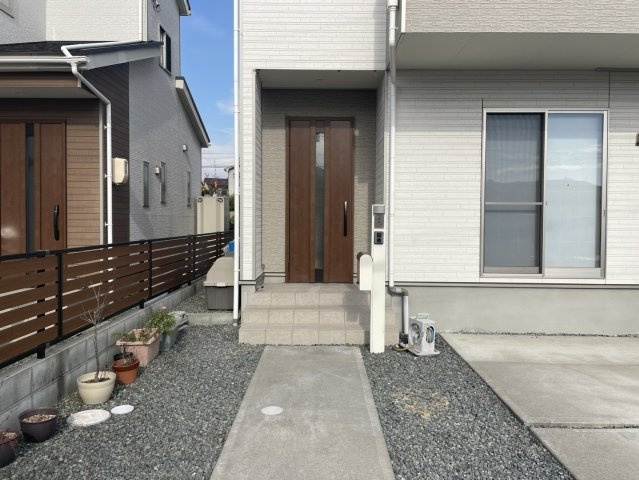 シンプルで清潔感のある玄関アプローチ。段差が少なくベビーカーや荷物の出し入れも楽々。周囲には植栽スペースもあり、季節の花を楽しむこともできます。前面道路も広く、駐車もしやすい安心の住環境です。