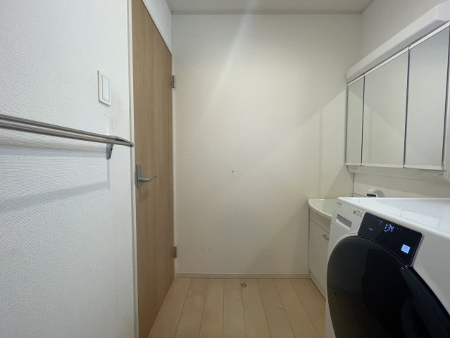 広々とした脱衣所は、洗濯動線が非常に使いやすい配置。洗面台・洗濯機が隣接し、家事がスムーズ。タオル掛けも備え付けられており使い勝手が良い空間です。清潔感のある白ベースで毎日の身支度が快適。