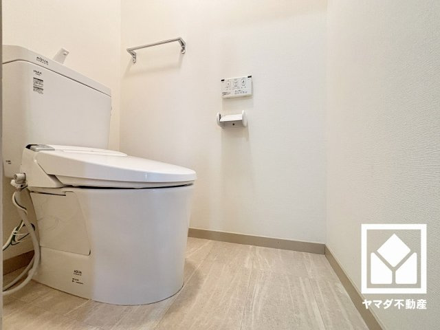 明るく清潔感溢れるトイレです。タオル掛けやペーパーホルダーが設置されています。
