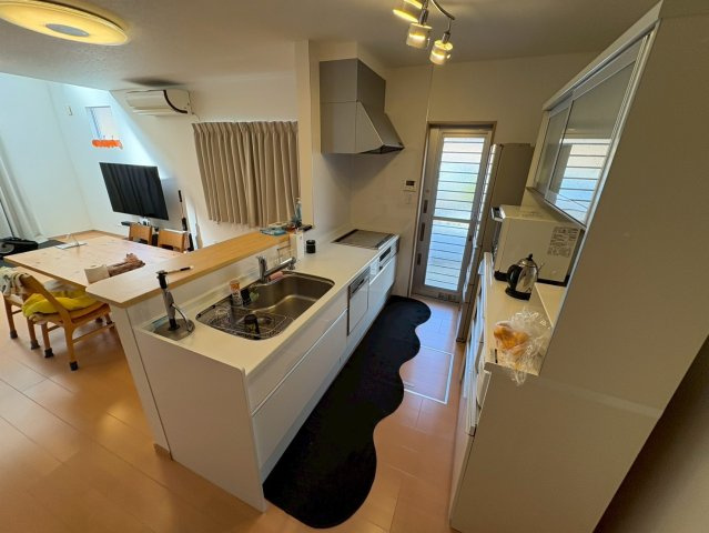 対面式キッチンで、リビングやダイニングを見渡しながら料理ができる空間です。通路幅にゆとりがあり、食器棚などの家具を置いても動線を妨げにくいのが魅力です。勝手口付きでゴミ出しや外への動線もスムーズです。