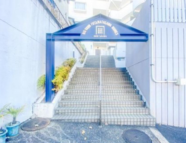白く明るい建物と階段のあるエントランスですね。