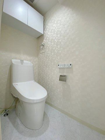 温水洗浄便座付きのトイレも新規交換済みで、清潔感あふれる空間に仕上がっています。トイレットペーパーや掃除用品をスマートに収納できる棚を完備しており、落ち着きのある洗練された空間を維持できます。