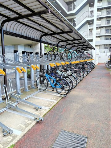 屋根付きの駐輪場を備え、自転車をすっきりと収容できるラック式を採用。日々の自転車利用にも便利な共用設備です。