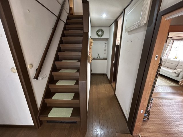 手すり付きで昇り降りしやすい階段は日常の移動を安心して行える設計。段板には滑りにくいマットが敷かれ家族の安全に配慮されています。壁面もすっきりとしており視界が明るく感じられるため圧迫感が少ないです。