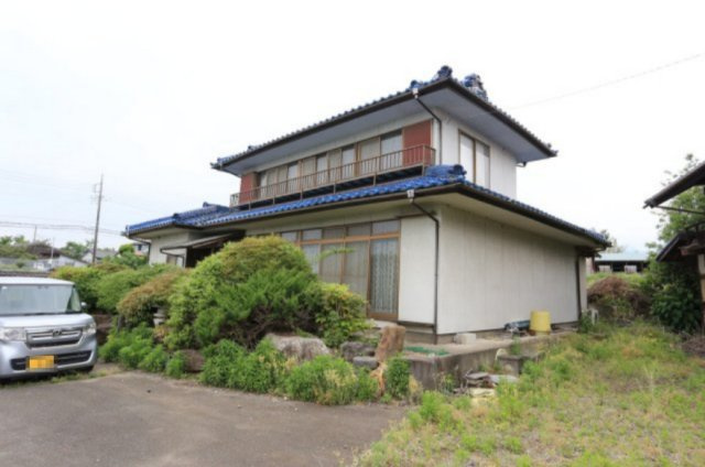 庭木や自然に囲まれた趣のある木造2階建ての住宅