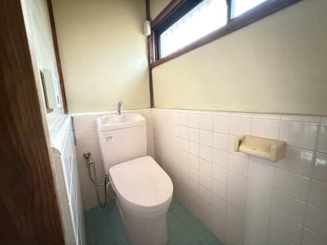 【明るく清潔感のあるトイレ】快適な温水洗浄機能付きの洋式トイレです。レトロな雰囲気もお洒落なタイル貼りの壁面が特徴。横長の大きな窓から自然光が入り、心地よい風を通せる開放的な空間です。