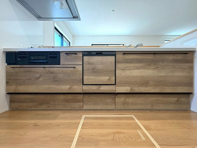 5号棟　室内の雰囲気と一体感のあるシステムキッチンは上品な質感です。　見た目だけではなく、たっぷりしまえる大容量収納で出しやすく、しまいやすいからキッチン周りはすっきりを保てます。