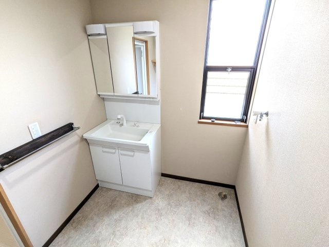 三面鏡付き、シャワータイプの洗面台と洗濯機置き場です。換気窓があり明るさも確保。