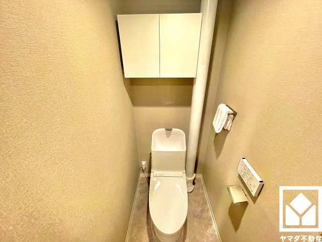 明るく清潔感溢れるトイレです。温水洗浄便座付きで、季節を問わずいつでも温かい便座をお使いいただけます。トイレットペーパーのストックや消耗品置き場などとしてお使いいただける吊戸棚がございます。