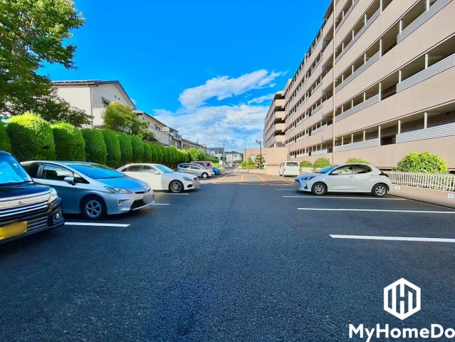 アスファルトや白線が綺麗に維持されており、周囲には整えられた緑豊かな生垣（植栽）が広がる気持ちの良い駐車環境です。