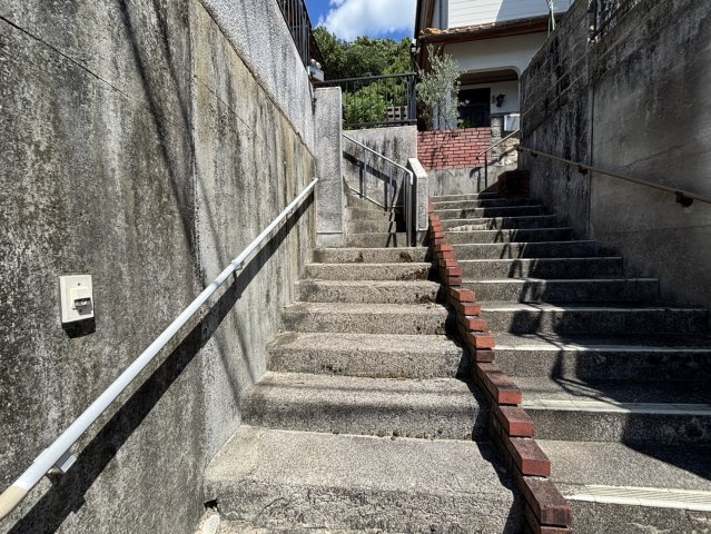 しっかりとした造りの階段アプローチは、安心感のある住まいへの導線です。手すりがあり、小さなお子様からご年配の方まで安全に昇降できる点が魅力です。シンプルながらも趣を感じられる空間となっています。