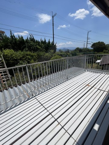 青空と遠方の山々を望む、開放的で広々としたバルコニー。