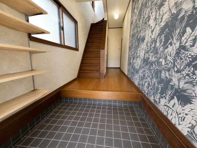 ゆとりある広さの玄関ホールは戸建ならではの開放感を感じられる空間です。木目調の床材とデザイン性の高いクロスが調和し落ち着いた雰囲気を演出。階段への動線もスムーズで家族や来客を気持ちよく迎えれる玄関です